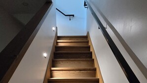 Uma escada de madeira com design moderno, que dá acesso a um andar superior.