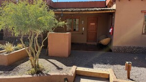 A building with a red roof, a wooden door labeled "TATTOO", and a fire extinguisher mounted on the wall. - Tambo Atacama Lodge (San Pedro de Atacama)