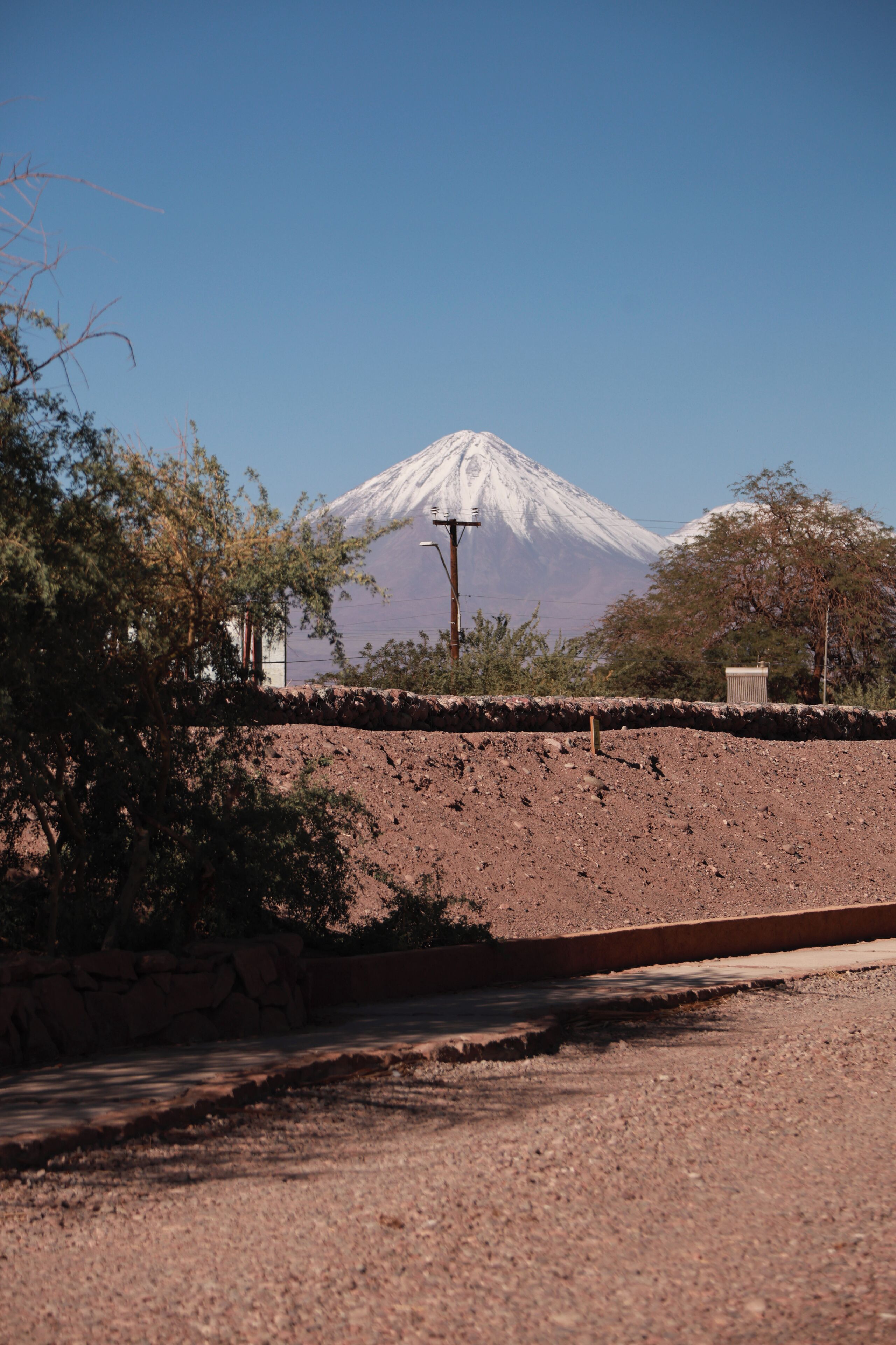 A road leading to a mountain with a clear sky.
