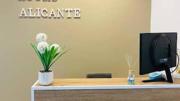 Una recepción con un cartel que dice "AS ROOMS ALICANTE" en el vestíbulo de un hotel.