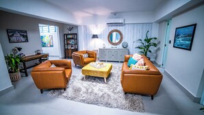 A modern living room with leather sofas, a coffee table, and a grey shag rug.