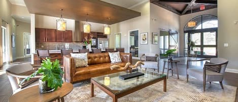 A spacious lobby with a leather sofa, a coffee table, and a dining area.