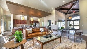 A spacious lobby with a leather sofa, a coffee table, and a dining area. - Landing | Chic 2BD, Gym (The Woodlands)
