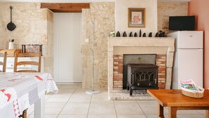 Una cocina acogedora con chimenea, una mesa de comedor y un televisor.