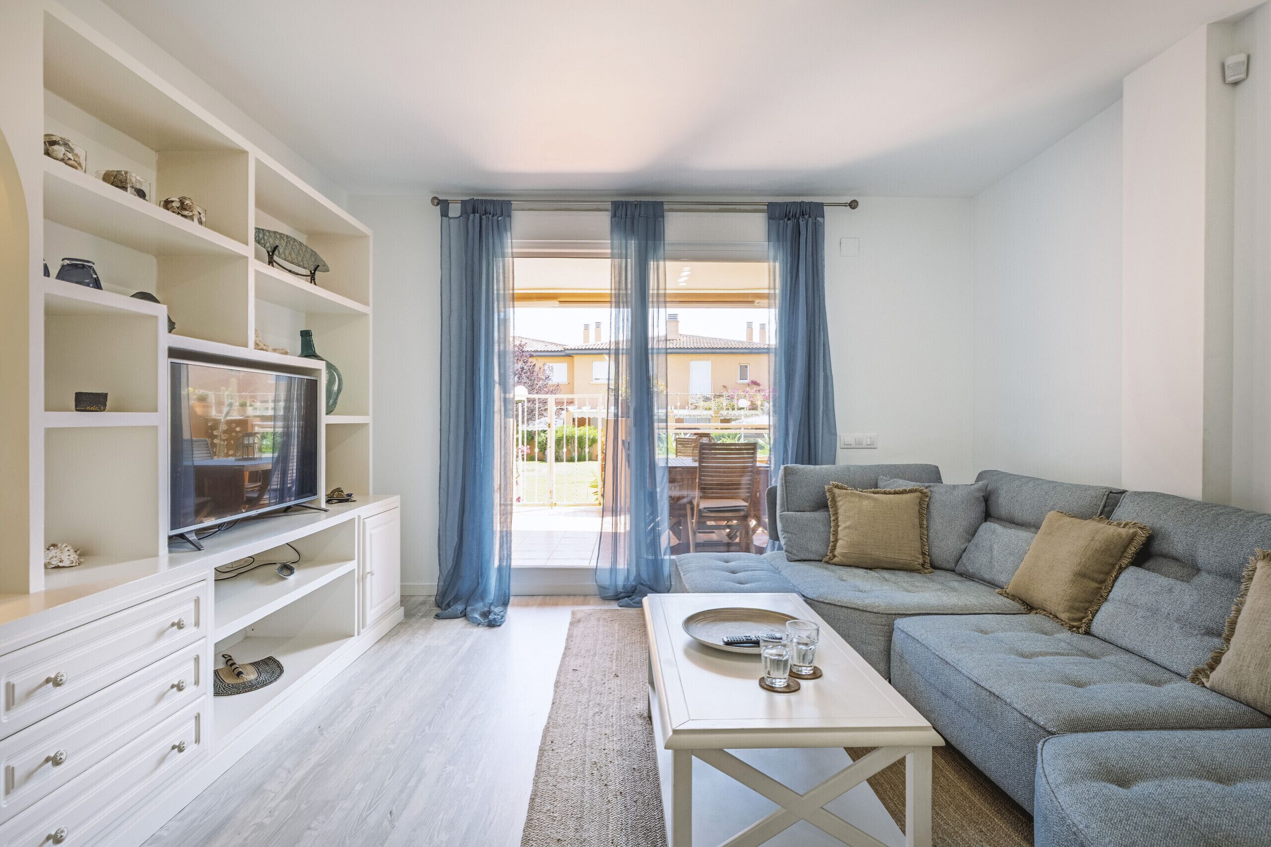 A living room with a sofa, TV, and shelves.