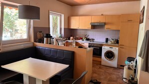 A compact kitchen with a dining area, built-in appliances, and a window providing natural light.