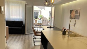 Une cuisine moderne dotée d’un plan de travail en marbre, d’un évier encastré et de luminaires suspendus.
