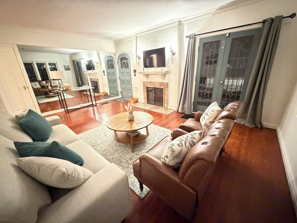 A living room with a sofa, a coffee table, and a fireplace.