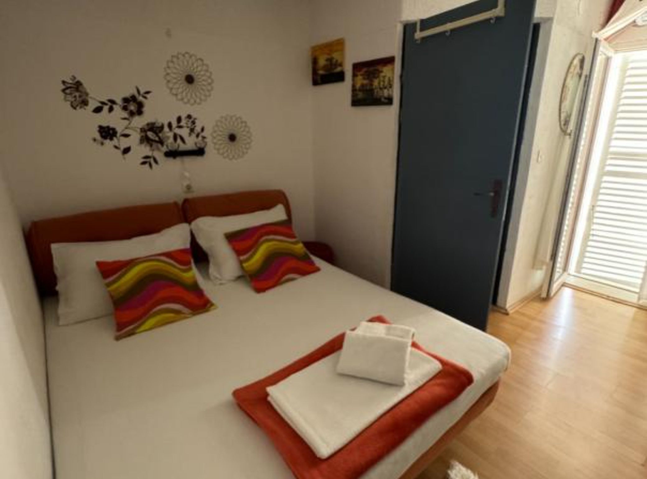 Ein Schlafzimmer mit Bett, Kissen, einem Nachttisch und einer Tür.