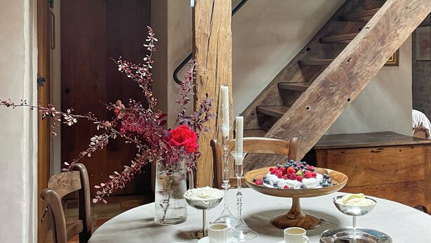 A dining table set with plates, cups, and a bowl of fruit. - Maison piscine & tennis partagés (Combreux)