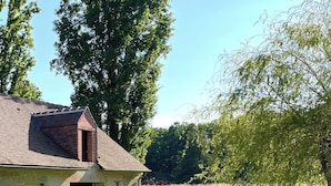 A rustic house with a brick chimney and a small porch. - Maison piscine & tennis partagés (Combreux)