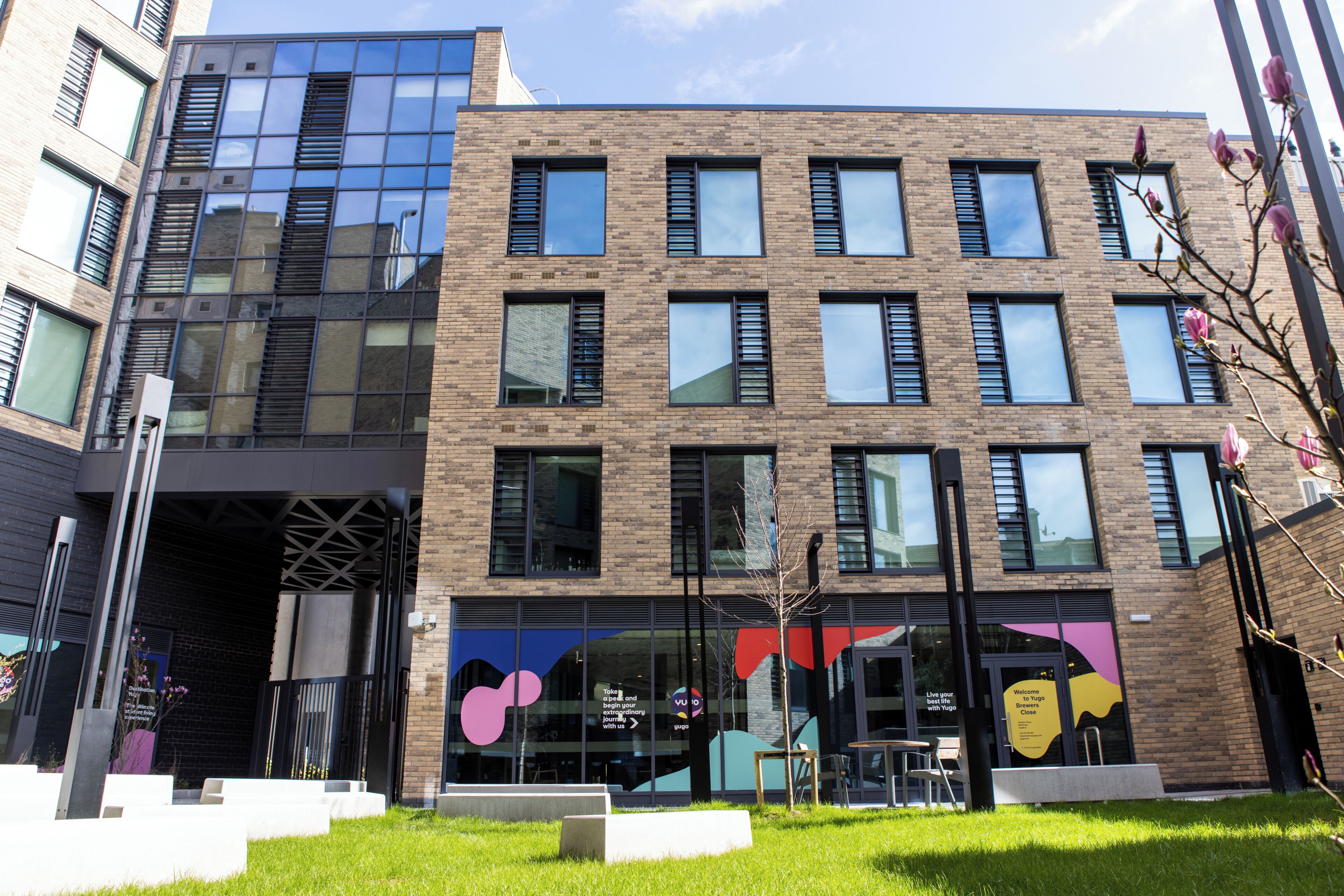 A modern building with a glass facade and a brick exterior.