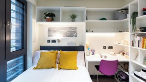 Una camera da letto moderna con un letto, una scrivania e una libreria.