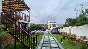 A modern outdoor area with a wooden staircase, a paved pathway, and outdoor seating. - ftrealtyproperties (Accra)