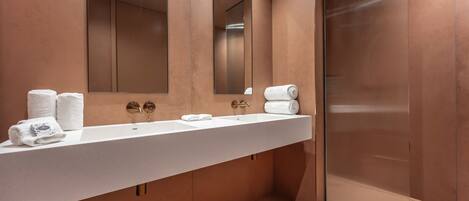 Un bagno moderno con uno specchio grande, un lavandino e una cabina doccia in vetro.