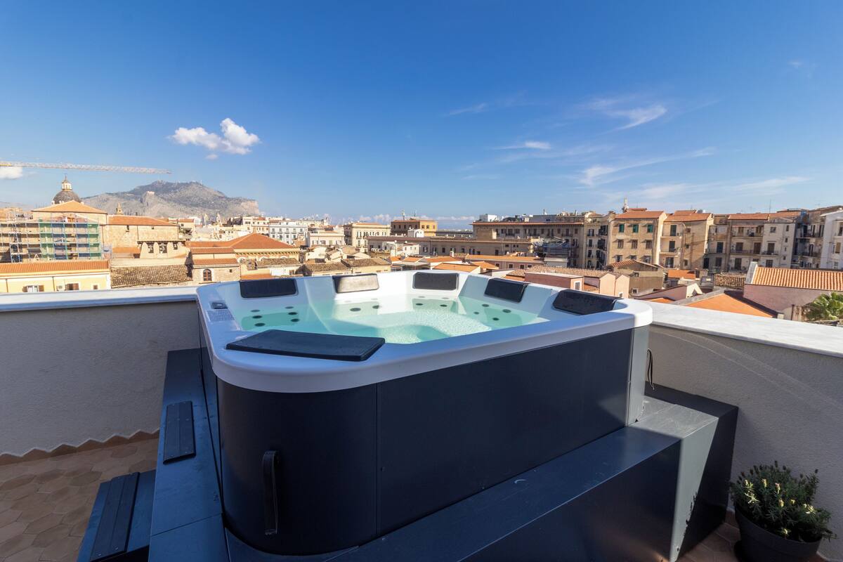 Un jacuzzi sur le toit offrant une vue panoramique sur la ville.