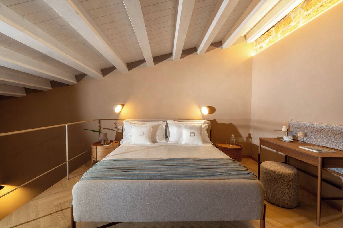 Une chambre à coucher avec un lit, des tables de chevet, un bureau et une chaise.