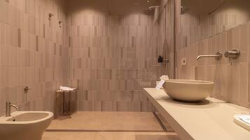 A modern bathroom with a freestanding bathtub, a large mirror, and a countertop with a bowl sink.