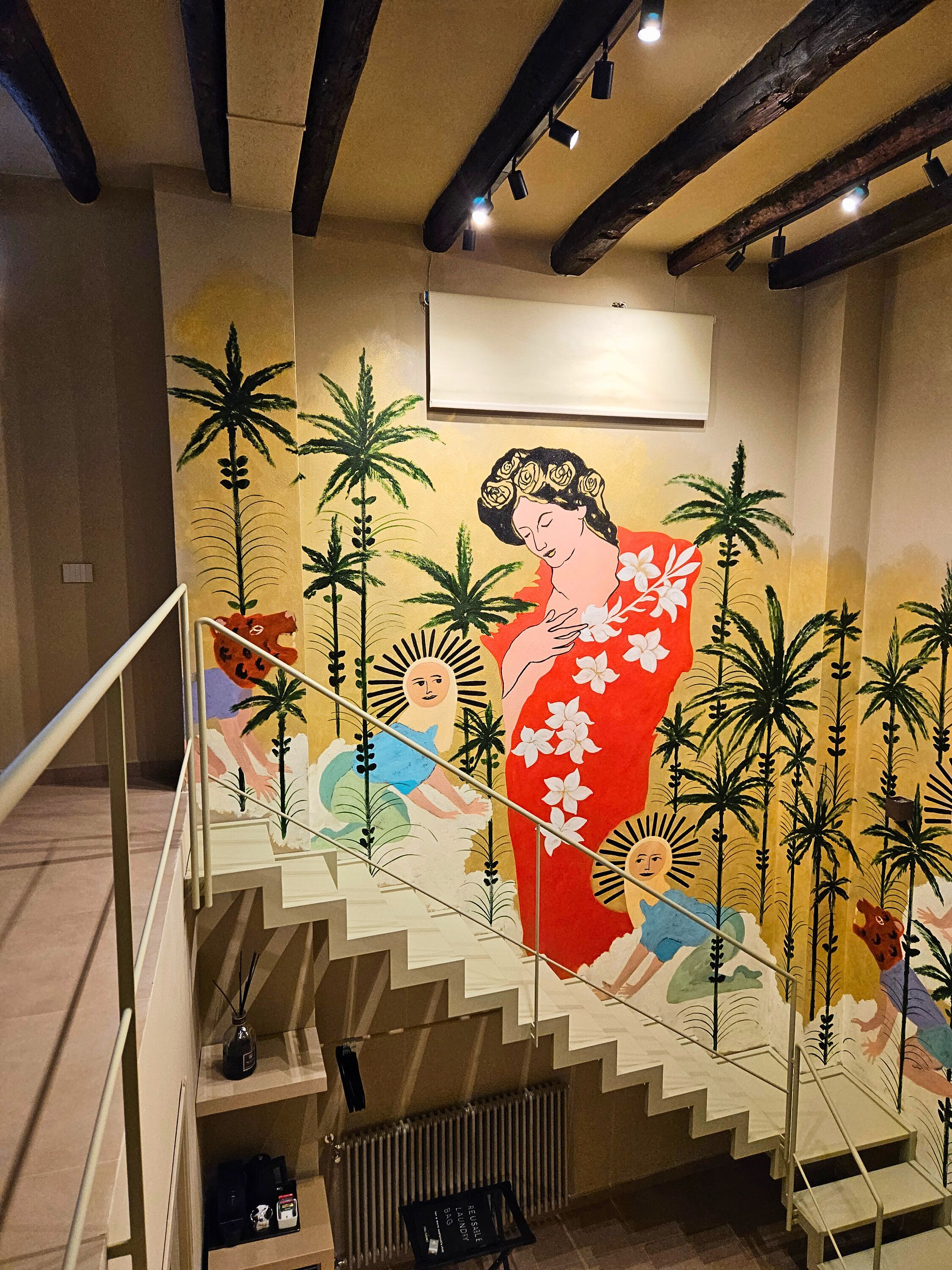 Una escalera con un mural que muestra a una mujer vestida con traje tradicional y palmeras.