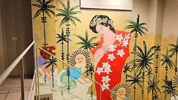Una escalera con un mural que muestra a una mujer vestida con traje tradicional y palmeras.
