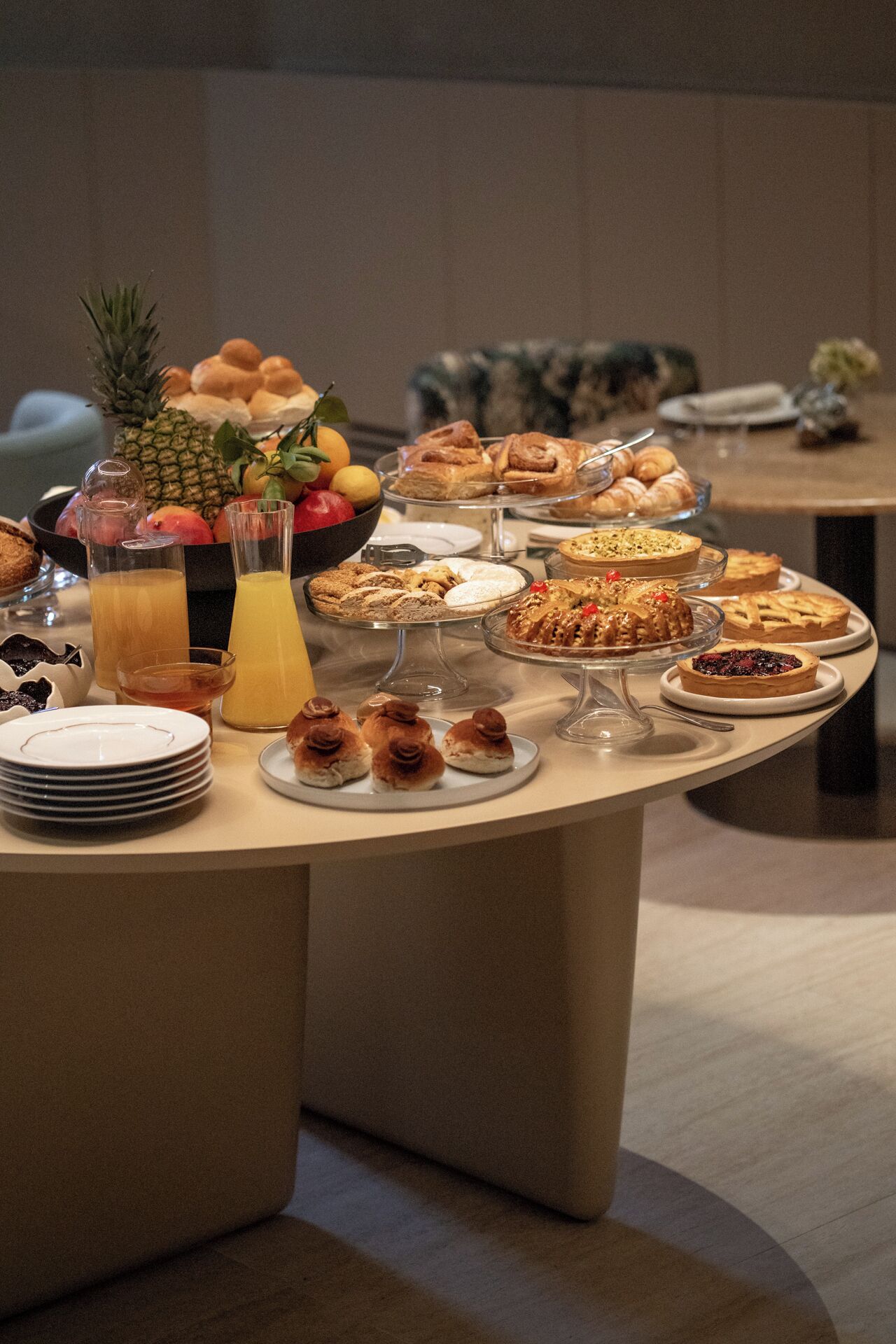 Une table de buffet proposant divers pâtisseries et fruits, ainsi qu’un saladier rempli de fruits.