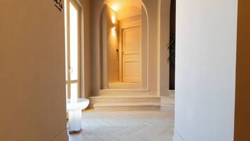 A hallway with a toilet, a door, and a staircase leading to another room.