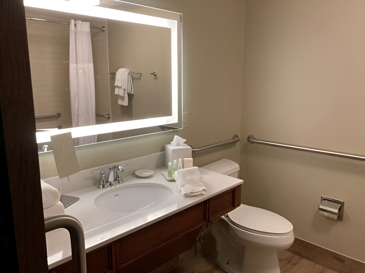 A bathroom with a sink, mirror, towel rack, and toilet.