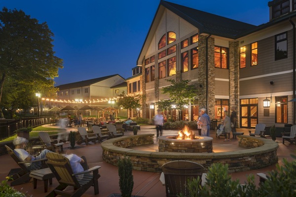 Golden hour settles over the Adirondack-style lodge, setting the tone for cozy evenings in front of a fire pit and patio.