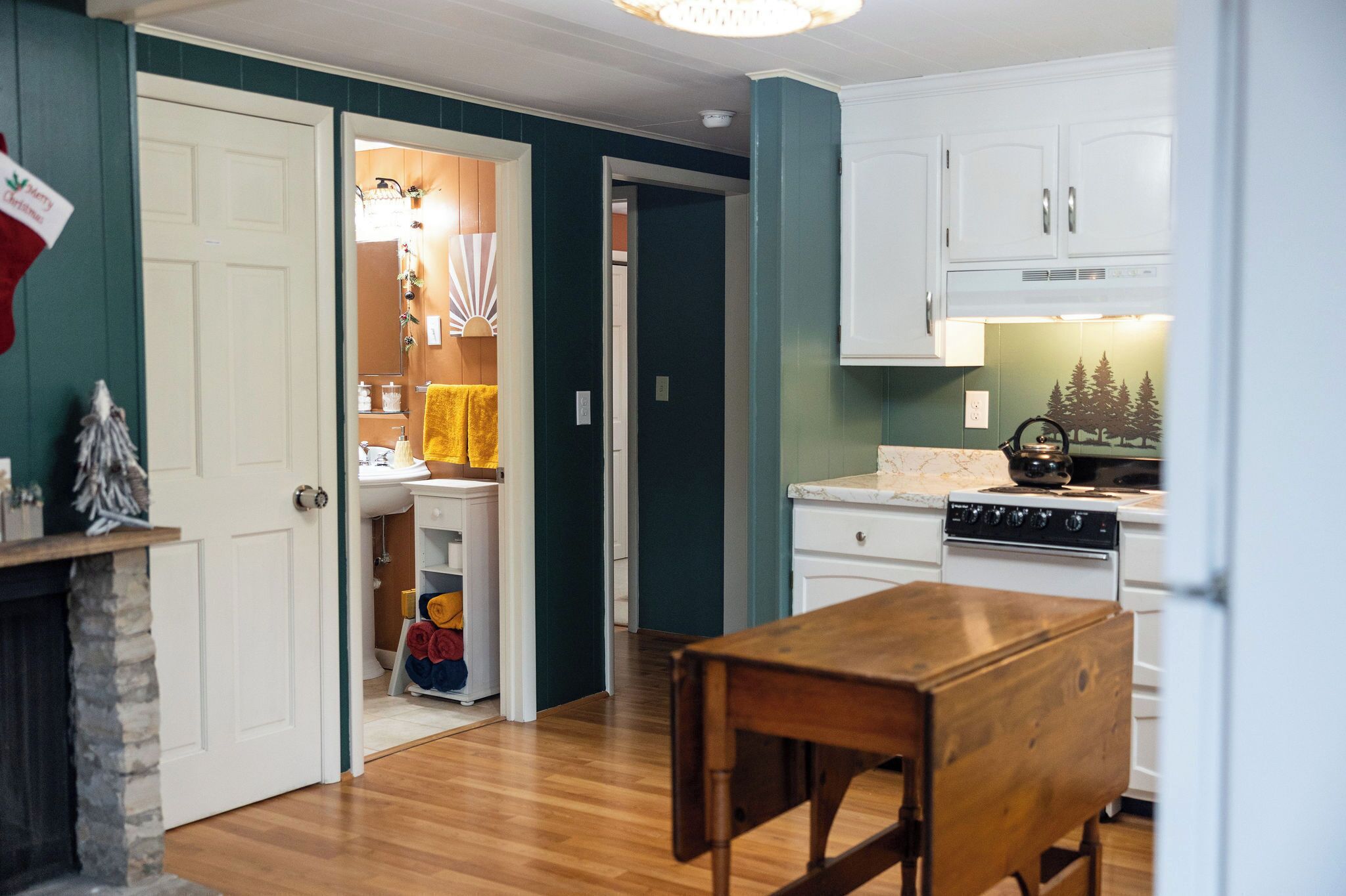 A kitchen with white cabinets, a wooden table, and a stove.