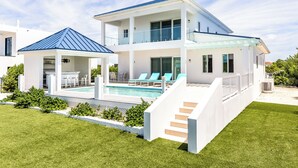 A modern two-story house with a pool, a covered patio, and a staircase leading to the upper level. - New Unique Villa Blue Top! 2 Bedrooms Waterfront with Kayak (Bay, Cooper Jack)