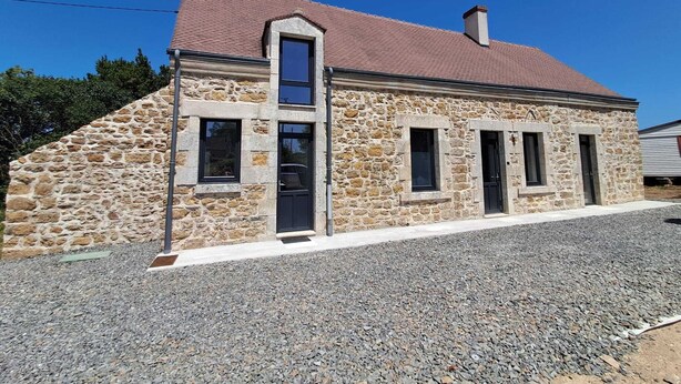 A stone building with a red-tiled roof, a central door, and two side doors. - Maison neuve 2 chambres au calme à Ceaulmont (Ceaulmont)