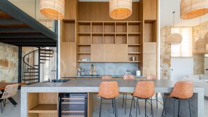 A modern kitchen with a central island, built-in shelves, and pendant lighting.