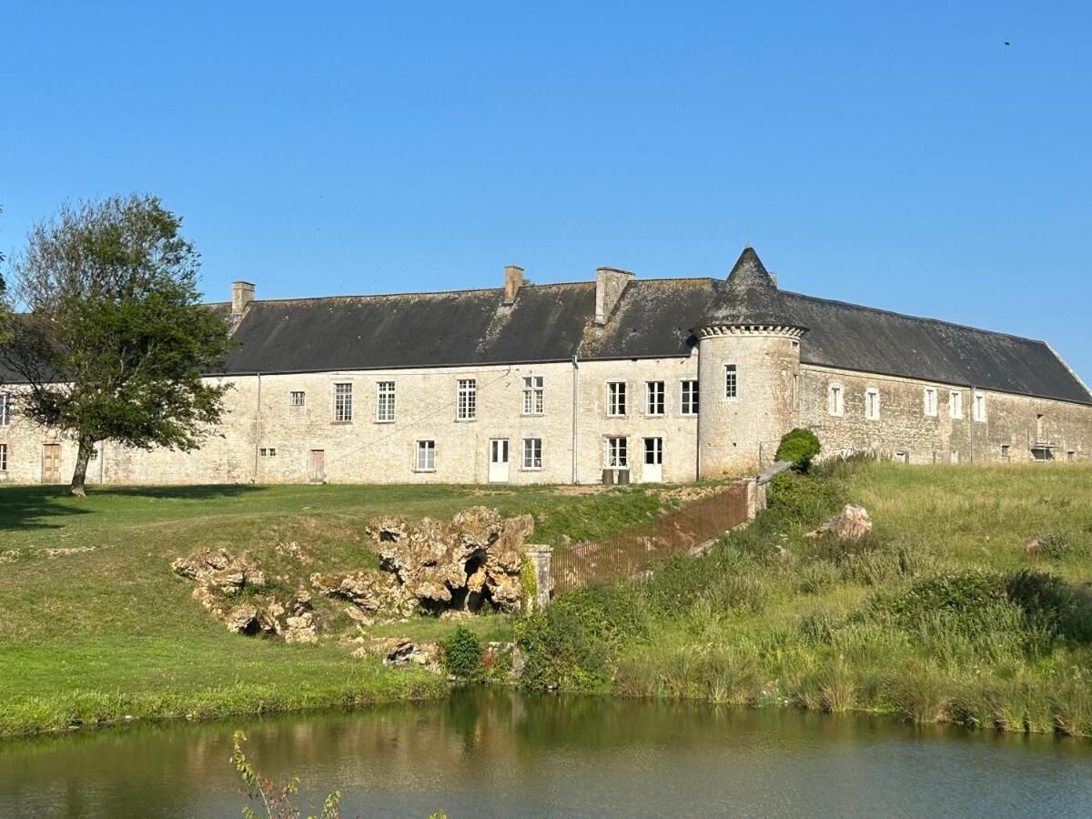A large stone building with a moat, likely a historic castle or manor.