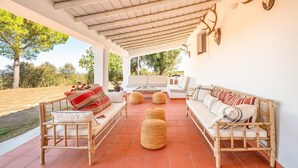 A covered outdoor seating area with wooden furniture and a stone floor. - Authentic Alentejo Farmhouse (Arraiolos)