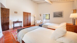 A bedroom with two beds, a wooden wardrobe, a small table, a chair, and a window with a view. - Authentic Alentejo Farmhouse (Arraiolos)