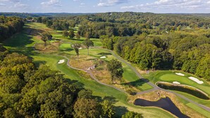 An aerial view of a golf course with multiple holes, surrounded by dense forest and rolling hills. - Charming 3-bedroom Ranch in Weston Near Westport & Fairfield (Weston)