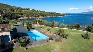 A pool area with lounge chairs and a view of the sea. - Villa Aigue Marine - Front de mer (Coti-Chiavari)