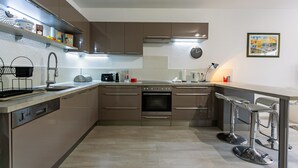 Une cuisine moderne dotée d’appareils électroménagers intégrés, d’un lave-vaisselle et d’un évier à deux bacs.