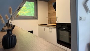 Une cuisine moderne dotée d’une lucarne, d’un plan de travail en bois et d’un four encastré.