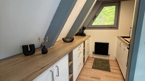 A modern kitchen with white cabinets, a wooden countertop, and a skylight. - Haus Majda - A place with heart, history and friendship (Ronshausen)