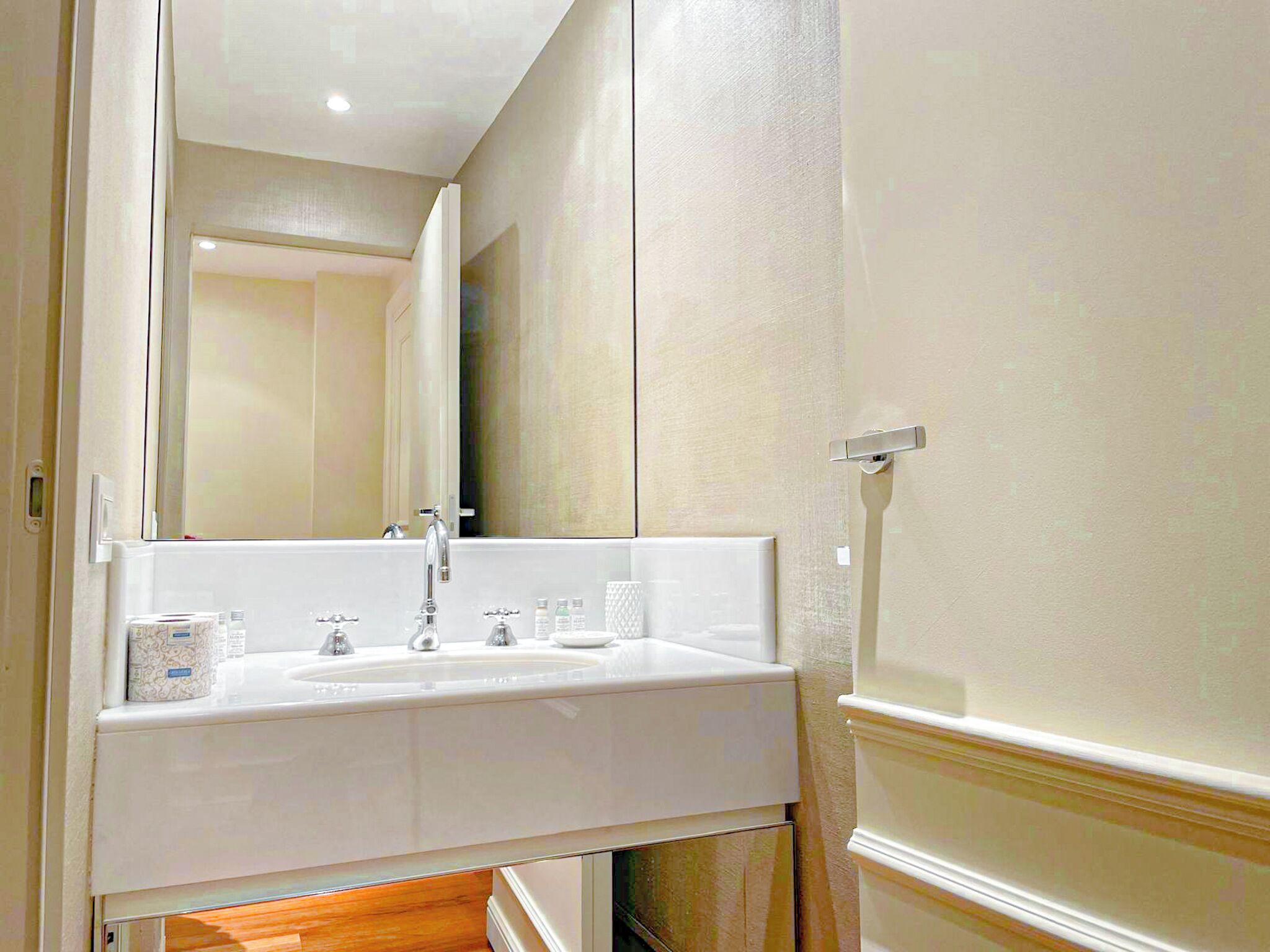 Een badkamer met een wit wastafelmeubel, spiegel en wastafel.
