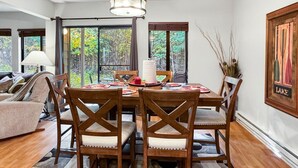 A dining area with a round table, four wooden chairs, and a rug with circular patterns. - Convenient Townhome Near Downtown McCall (McCall)