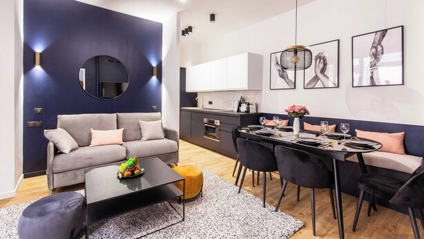 Un salon moderne avec un canapé, une table basse et un coin repas.