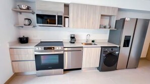 Een moderne keuken met roestvrijstalen apparatuur, houten kastjes en een inbouwvaatwasser.
