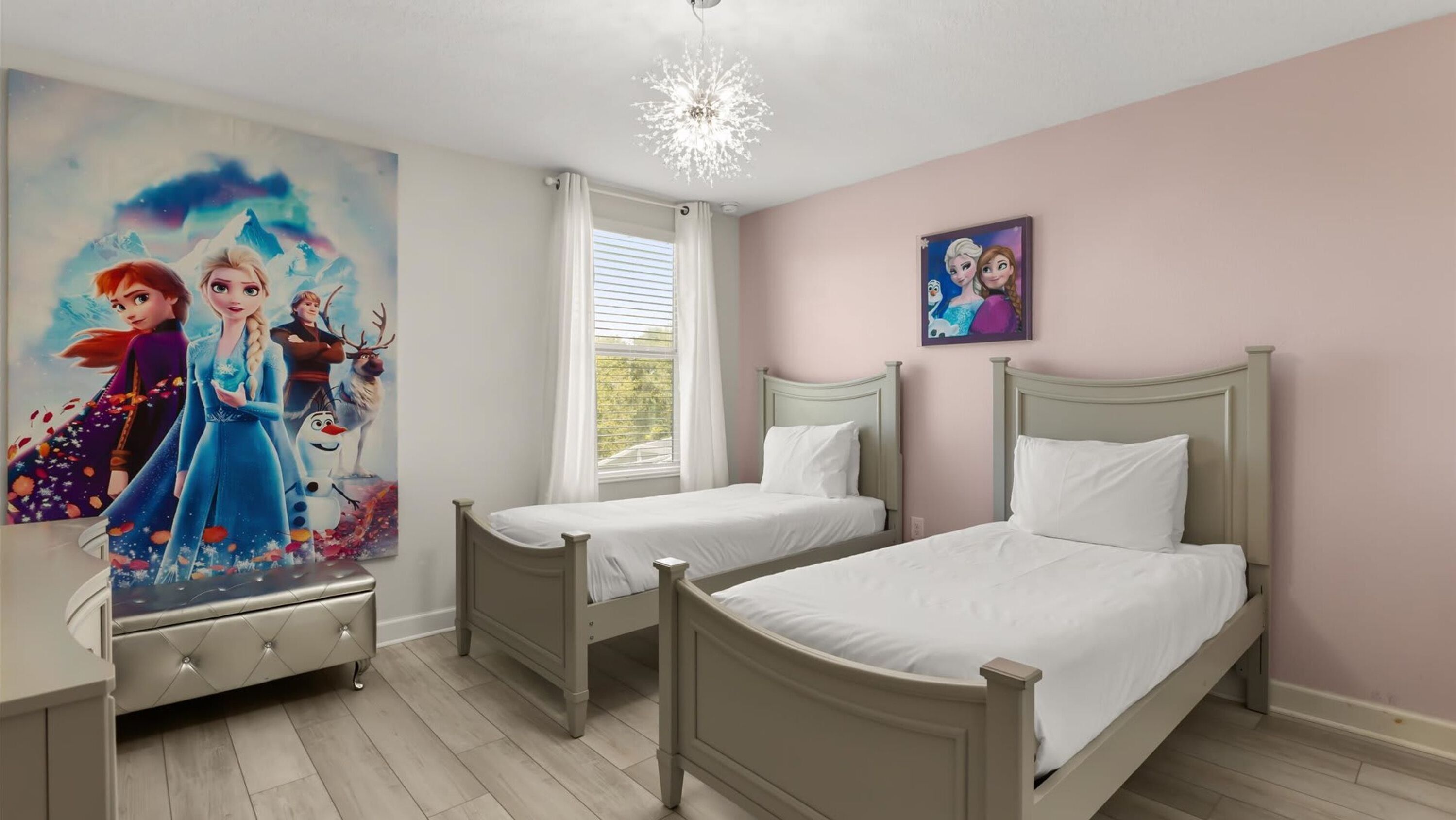 Een slaapkamer met twee bedden, een dressoir, een raam met gordijnen en een plafondlamp.