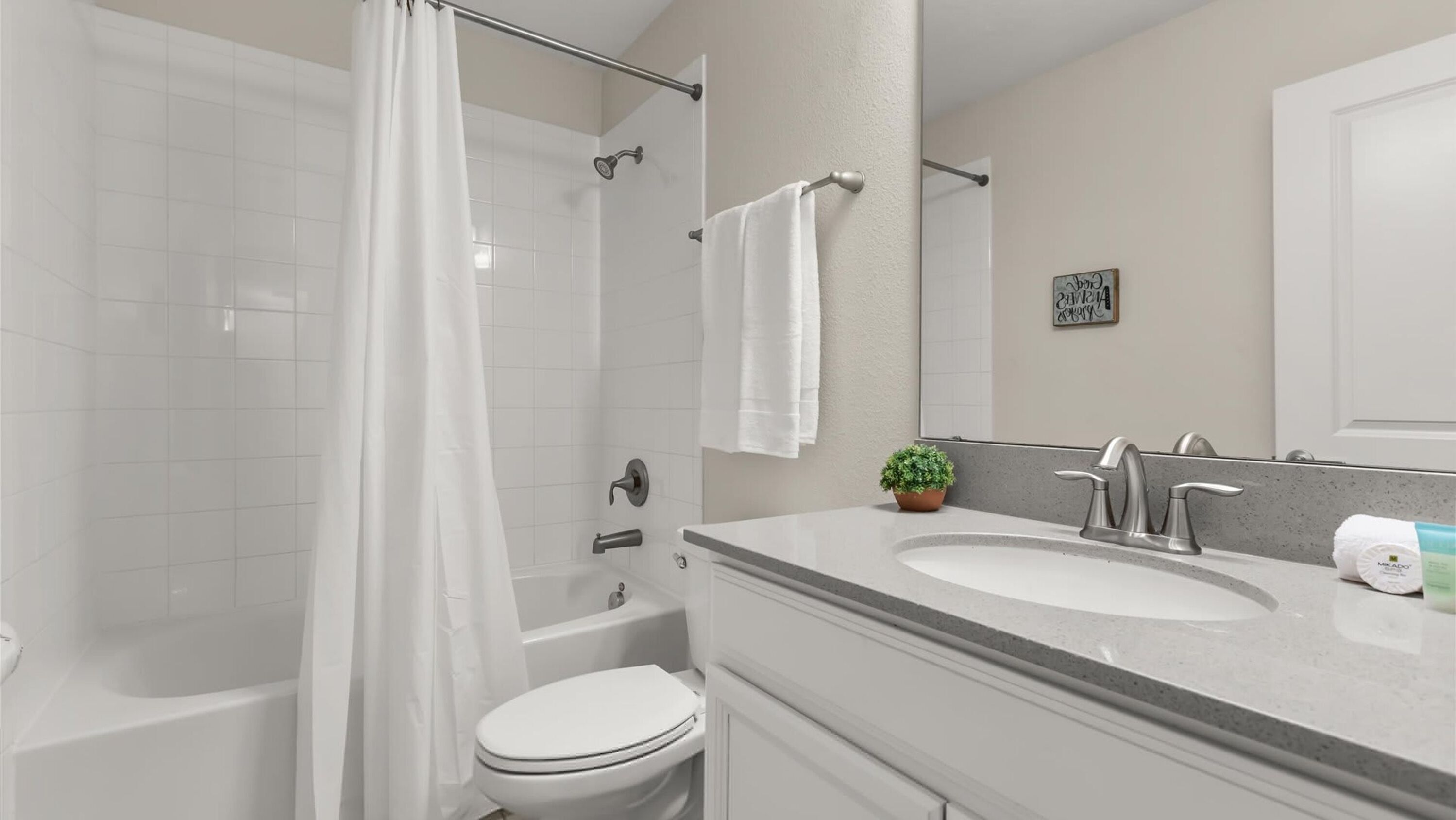 Ein modernes Badezimmer mit Badewanne, Toilette und Waschbecken.