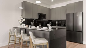 A modern kitchen with a central island, stainless steel appliances, and a minimalist design. - Upstay-luxury 3BR Home w Private Pool Games Room (Clermont)