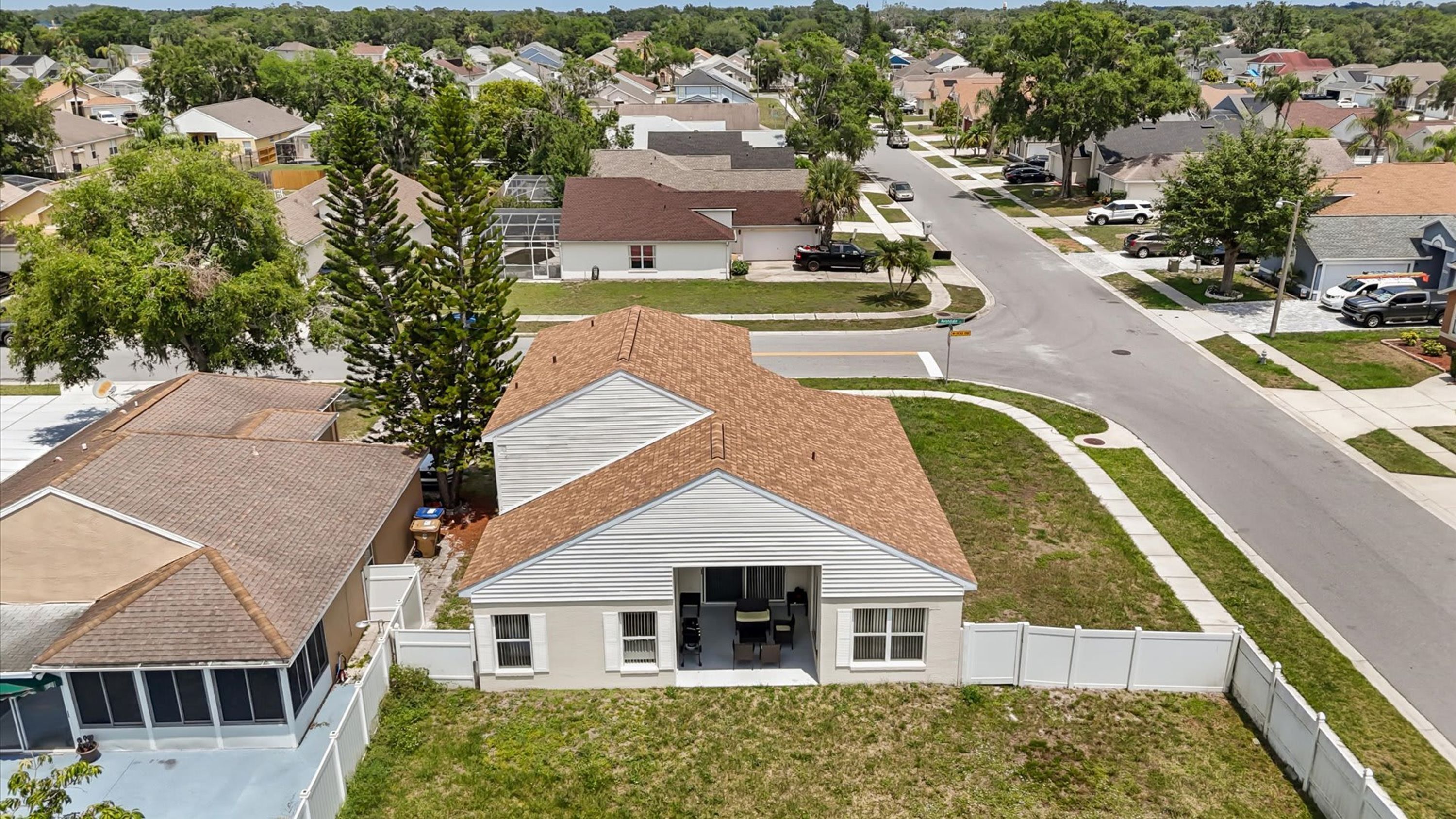 A residential neighborhood with houses, a street, and a large tree.