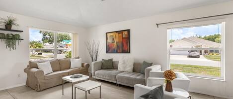 A spacious living room with two sofas, a coffee table, and a painting.