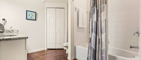 A bathroom with a shower, toilet, and sink.